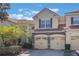 Townhome with two-car garage, featuring a stone facade and manicured landscaping at 7189 Regina Way, Orlando, FL 32819