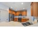 A modern kitchen featuring stainless steel appliances, wooden cabinetry, and a spacious countertop at 7189 Regina Way, Orlando, FL 32819