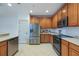Well-equipped kitchen featuring stainless steel appliances, wooden cabinets, and tile flooring at 7189 Regina Way, Orlando, FL 32819