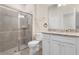Bathroom with glass shower, granite vanity, and white cabinets at 7343 Oakmoss Loop, Davenport, FL 33837