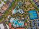 Bird's eye view of a community pool, lazy river, tennis courts, cabanas, and lush landscape, perfect for relaxation at 7343 Oakmoss Loop, Davenport, FL 33837