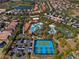 Overhead view of a community featuring a luxurious pool, lazy river, tennis courts, and well-maintained landscaping at 7343 Oakmoss Loop, Davenport, FL 33837