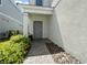 Inviting front entrance with a brick pathway leading to a gray front door and covered porch at 7343 Oakmoss Loop, Davenport, FL 33837