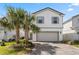 Charming two-story home with a two-car garage and a brick-paved driveway, framed by lush palm trees at 7343 Oakmoss Loop, Davenport, FL 33837