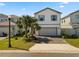 Charming two-story home featuring a two-car garage, well-manicured lawn, and beautiful palm trees at 7343 Oakmoss Loop, Davenport, FL 33837