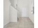 Bright foyer featuring tile floors, a staircase, and a white front door with sidelight at 7343 Oakmoss Loop, Davenport, FL 33837
