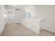 Well-lit upstairs hallway featuring neutral carpet and white trim at 7343 Oakmoss Loop, Davenport, FL 33837