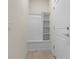 Bright mudroom features built-in storage with shelves, cabinet, and a bench, next to the door at 7343 Oakmoss Loop, Davenport, FL 33837