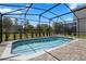 Screened in pool area with a view of the green backyard at 7343 Oakmoss Loop, Davenport, FL 33837