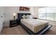 A modern bedroom with a sleek black platform bed, side tables, and plush carpeting at 9023 Dogleg Dr, Davenport, FL 33896