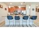 An open-concept kitchen with stainless steel appliances, granite countertops, and four modern bar stools at 9023 Dogleg Dr, Davenport, FL 33896