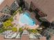 Aerial view of the community swimming pool surrounded by lounge chairs and lush greenery at 911 N Orange Ave # 352, Orlando, FL 32801