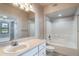 Bright bathroom featuring a large mirror, single vanity and a shower over tub with white tile surround at 911 N Orange Ave # 352, Orlando, FL 32801