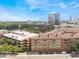 Detailed exterior view of a multi-story building near a parking garage, with lush greenery in the foreground at 911 N Orange Ave # 352, Orlando, FL 32801