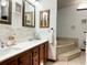 This bathroom features double vanity, decorative framed mirrors, and a sunken jacuzzi bathtub on a raised platform at 9145 Floribunda Dr, Orlando, FL 32818