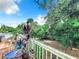 Inviting backyard deck, perfect for outdoor relaxation, is surrounded by lush greenery, offering shade and privacy at 9263 Lake Lotta Cir, Gotha, FL 34734
