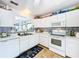 Bright kitchen with white cabinets, modern appliances, and a charming blue-and-white tile backsplash at 9263 Lake Lotta Cir, Gotha, FL 34734