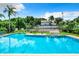 Sparkling community pool with lush tropical landscaping and lounge chairs around the perimeter at 9263 Lake Lotta Cir, Gotha, FL 34734