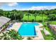 Community pool with lounge chairs, palm trees, and lush landscaping offers a refreshing outdoor retreat at 9263 Lake Lotta Cir, Gotha, FL 34734