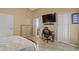 Bedroom with desk, tv, closet, and adjacent bathroom at 9664 Lake Douglas Pl, Orlando, FL 32817