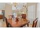 Open dining room with a wooden table set and a view into the living room and out to the pool at 9664 Lake Douglas Pl, Orlando, FL 32817