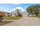 Charming single Gathering home featuring a well-manicured lawn, mature landscaping, and a two-car garage at 9664 Lake Douglas Pl, Orlando, FL 32817
