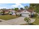 Well-kept single Gathering home with an attached two car garage, mature landscaping, and a concrete driveway at 9664 Lake Douglas Pl, Orlando, FL 32817