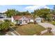 Home with a well-manicured front yard, mature trees, and a driveway leading to an attached two-car garage at 9664 Lake Douglas Pl, Orlando, FL 32817