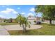 View of the driveway leading to an attached two-car garage; well manicured front lawn with mature trees at 9664 Lake Douglas Pl, Orlando, FL 32817