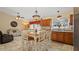 Bright kitchen featuring tile floors, wood cabinets, and an adjacent sitting area at 9664 Lake Douglas Pl, Orlando, FL 32817