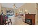 Living room area featuring a fireplace, sliding glass doors opening to the pool area, and neutral decor at 9664 Lake Douglas Pl, Orlando, FL 32817