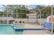 Screened-in pool area with a large pool and spa, surrounded by lush landscaping at 9664 Lake Douglas Pl, Orlando, FL 32817
