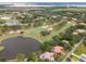 Expansive golf course view of home surrounded by lush greenery and serene pond at 120 W Magnolia Ave, Howey In The Hills, FL 34737