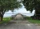 Picturesque view of a wooden dock with a gazebo, framed by trees, extending into a tranquil lake at 120 W Magnolia Ave, Howey In The Hills, FL 34737