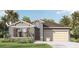 One-story home with gray siding, brown door, and beige garage at 1273 Limbali St, Mount Dora, FL 32757