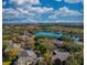 Aerial view showcasing a serene lake surrounded by lush greenery and residential buildings, with a clear blue sky overhead at 1341 Arbor Vista Loop # 321, Lake Mary, FL 32746