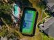 Aerial view of the tennis court next to a swimming pool surrounded by lush greenery at 1341 Arbor Vista Loop # 321, Lake Mary, FL 32746