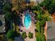 Aerial view of a pool featuring lounge chairs and manicured greenery, surrounded by buildings at 1341 Arbor Vista Loop # 321, Lake Mary, FL 32746