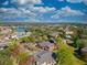 Expansive aerial view showcasing a residential area with a lake, lush greenery, and diverse architectural styles under a partly cloudy sky at 1341 Arbor Vista Loop # 321, Lake Mary, FL 32746