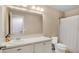 Clean bathroom with a large mirror, white cabinets, a toilet, and a shower with a white curtain at 13829 Ingelnook Dr, Windermere, FL 34786