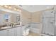 Well-appointed bathroom with double sinks, granite countertops, a soaking tub, and a separate glass-enclosed shower at 13829 Ingelnook Dr, Windermere, FL 34786