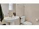 Powder room with a pedestal sink, a faucet with brown soap dispenser bottles, and a toilet at 13829 Ingelnook Dr, Windermere, FL 34786