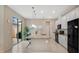 Modern kitchen with a granite countertop island, stainless steel appliances, and sliding glass doors to the patio at 13829 Ingelnook Dr, Windermere, FL 34786