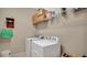 Functional laundry room with a white washer and dryer, storage shelves, and a white bucket on the floor at 13829 Ingelnook Dr, Windermere, FL 34786