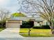 Charming single-story home with a well-manicured lawn, mature tree, and attached two car garage at 14872 Faversham Cir, Orlando, FL 32826