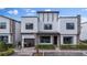 Modern three-story home with attached garage and landscaped front yard at 153 Villa Domani Cir, Davenport, FL 33896