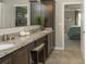 Double vanity bathroom with granite countertop and large mirror at 1575 Weaver Oak Way, Deland, FL 32720