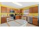 Functional kitchen with wooden cabinets, modern appliances, and a cozy breakfast table with tile accents at 2029 Knollcrest Dr, Clermont, FL 34711