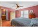 Inviting main bedroom features a ceiling fan, wood floors and an en-suite bathroom at 2029 Knollcrest Dr, Clermont, FL 34711