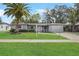 Charming single-story home with a well-manicured lawn and a beautiful mature palm tree at 2049 Jefferson Ave, Deltona, FL 32738